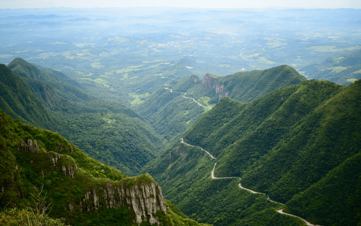 Eine kurvenreiche Straße schlängelt sich durch üppig grüne Berge und bietet einen beeindruckenden Blick auf die Landschaft.