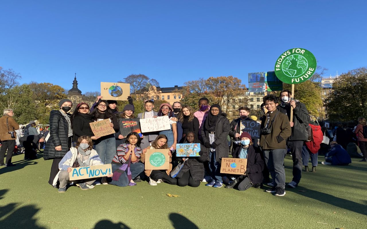 Eine Gruppe von Menschen versammelt sich in Stockholm mit Schildern von Fridays for Future, um für Klimaschutz zu demonstrieren.