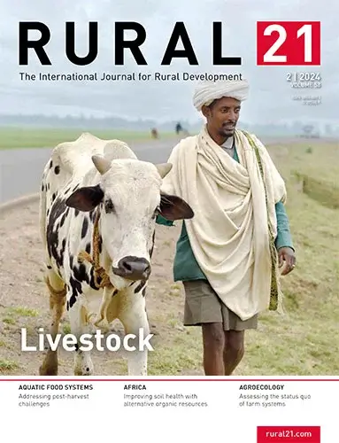 A man in traditional attire walks alongside a cow on a rural path, featured on the 2024 cover of a rural development journal.