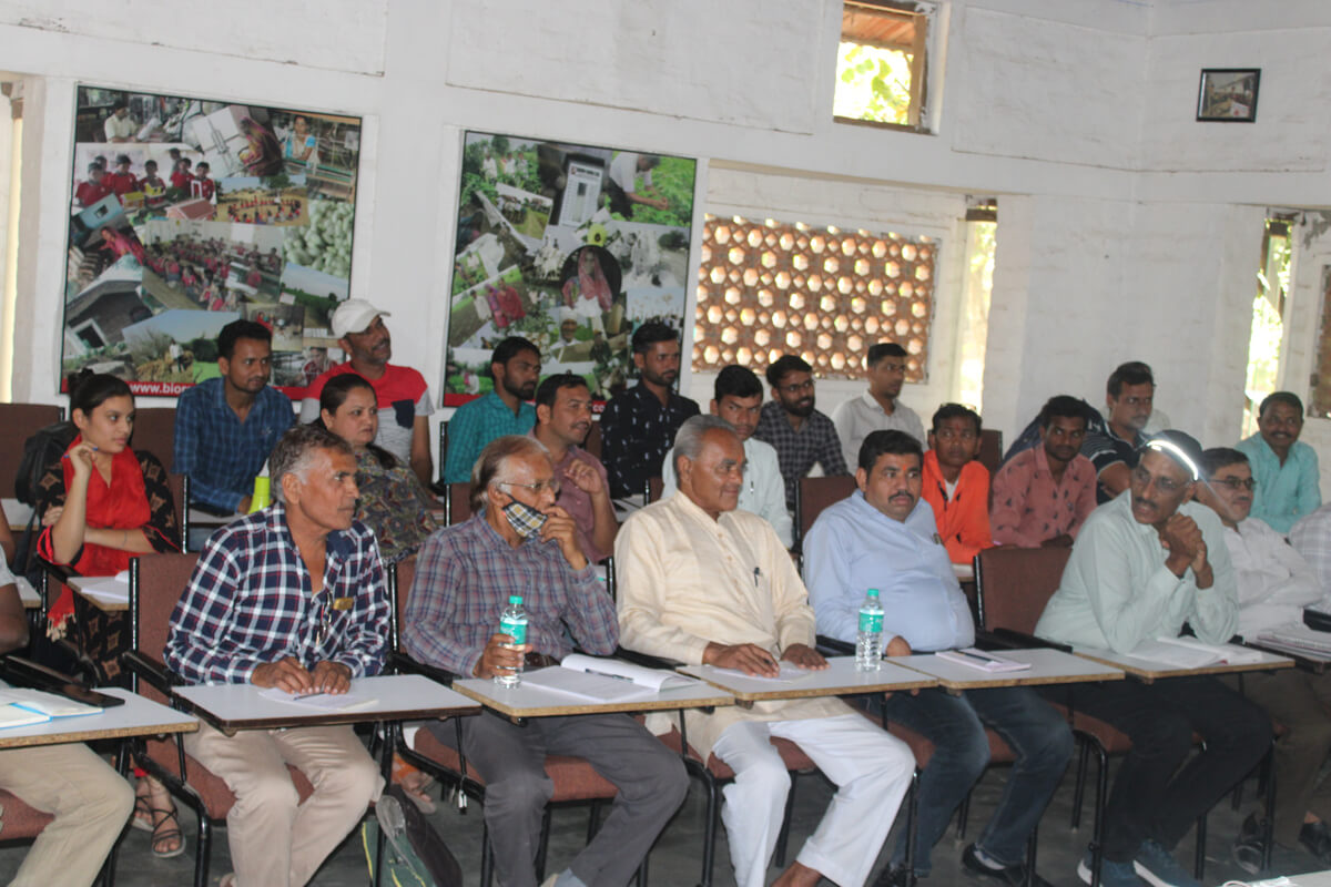 Eine Gruppe von Menschen sitzt aufmerksam in einem Seminarraum und verfolgt eine Präsentation.